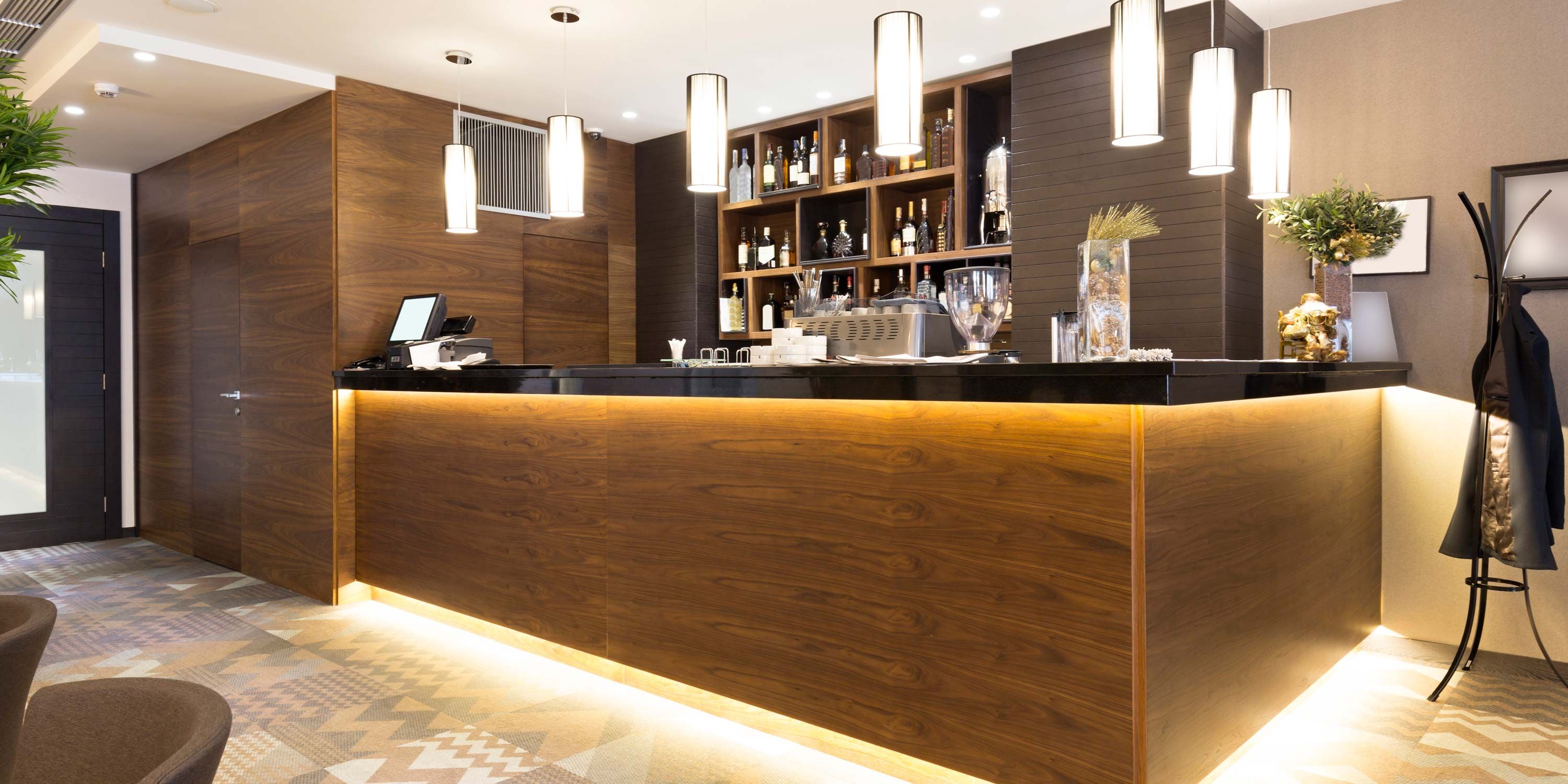 wooden bar in a hotel lobby with LED lighting